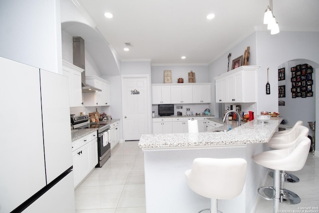 kitchen with decorative backsplash, stainless steel range with electric stovetop, a sink, and freestanding refrigerator