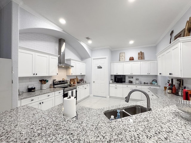 kitchen featuring stainless steel range with electric stovetop, ornamental molding, backsplash, a sink, and wall chimney range hood