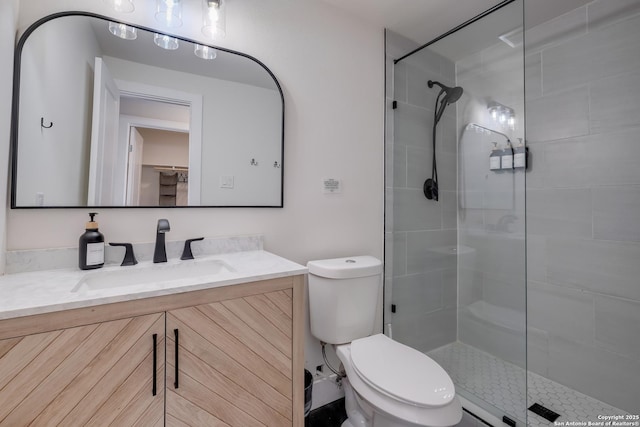 full bathroom with a tile shower, toilet, and vanity