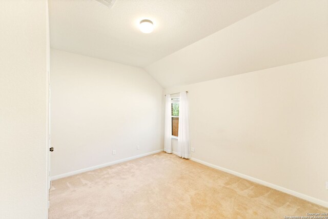 26823 Rustic Brk, San Antonio, TX 78261 - spare room featuring baseboards, light colored carpet, and vaulted ceiling