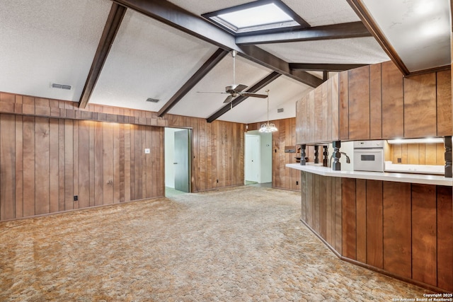 10103 Northampton, San Antonio, TX 78230 - kitchen featuring oven, wood walls, brown cabinetry, light colored carpet, and light countertops