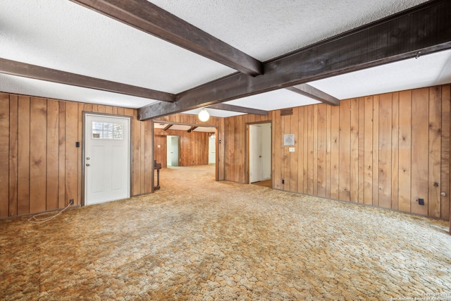10103 Northampton, San Antonio, TX 78230 - unfurnished living room with carpet, beam ceiling, a textured ceiling, and wooden walls