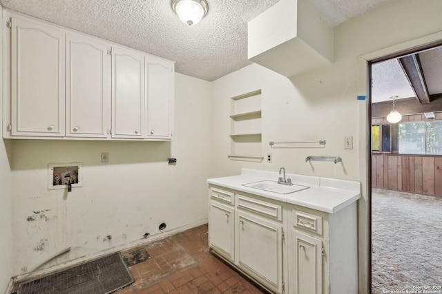 10103 Northampton, San Antonio, TX 78230 - laundry room featuring washer hookup, a textured ceiling, cabinet space, and brick patterned floors