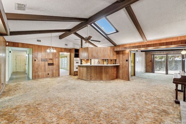 10103 Northampton, San Antonio, TX 78230 - kitchen featuring wooden walls, open floor plan, carpet floors, a textured ceiling, and plenty of natural light