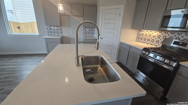 14710 Prairie Clover, San Antonio, TX 78253 - kitchen with appliances with stainless steel finishes, gray cabinetry, baseboards, a sink, and dark wood-type flooring