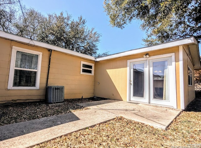 back of property with a patio and central AC