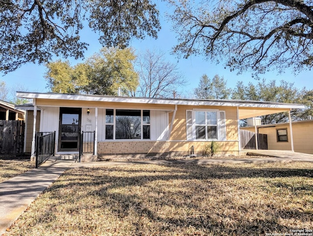 view of front of property featuring a carport, a front yard, and fence