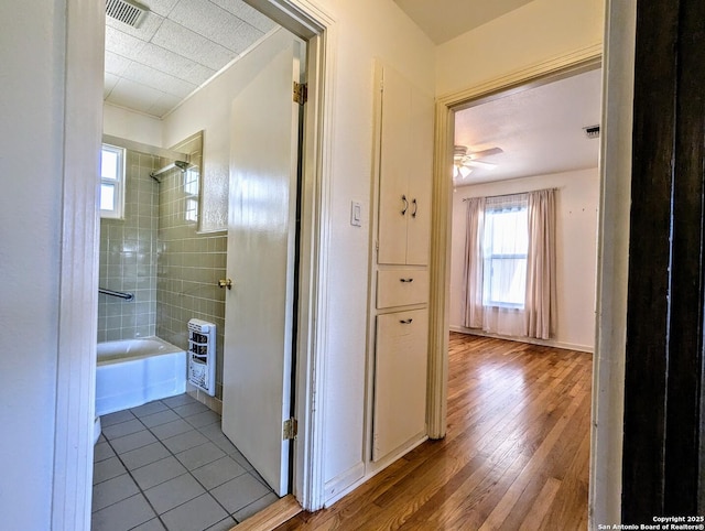 hallway with visible vents and wood finished floors