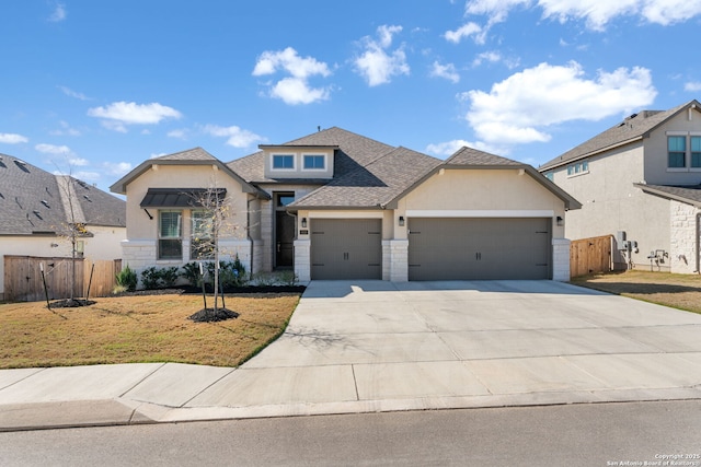 view of front of house with driveway, stone siding, fence, a front yard, and a garage