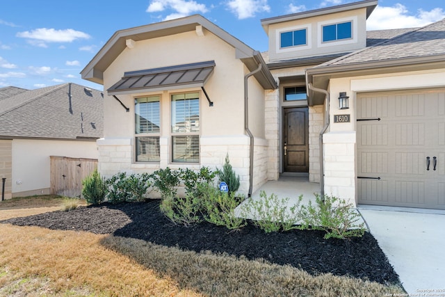 view of front facade featuring stone siding, stucco siding, concrete driveway, and a garage