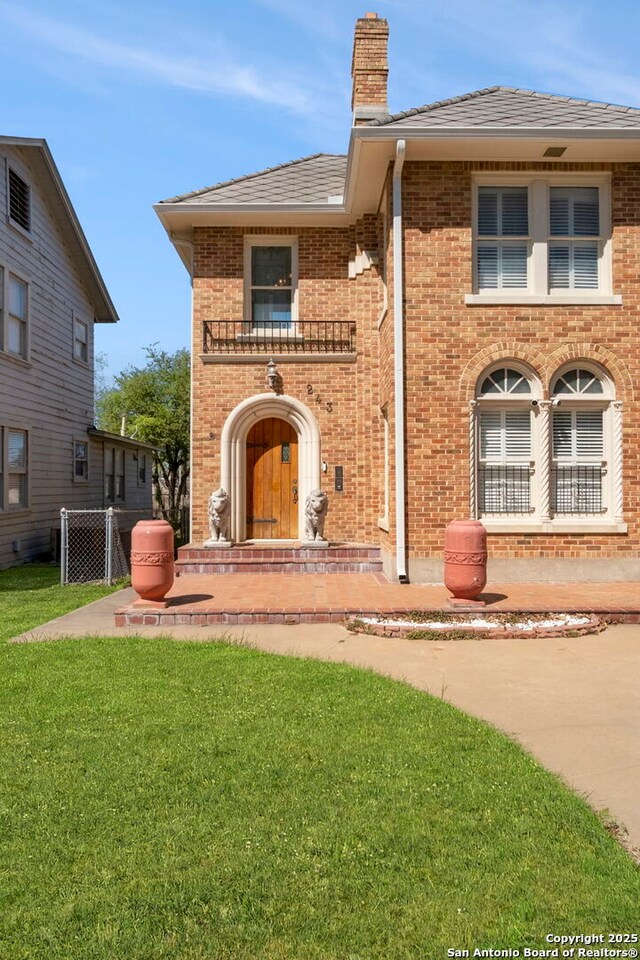 243 E Lullwood, San Antonio, TX 78212 - view of front facade featuring a front yard, brick siding, and a chimney