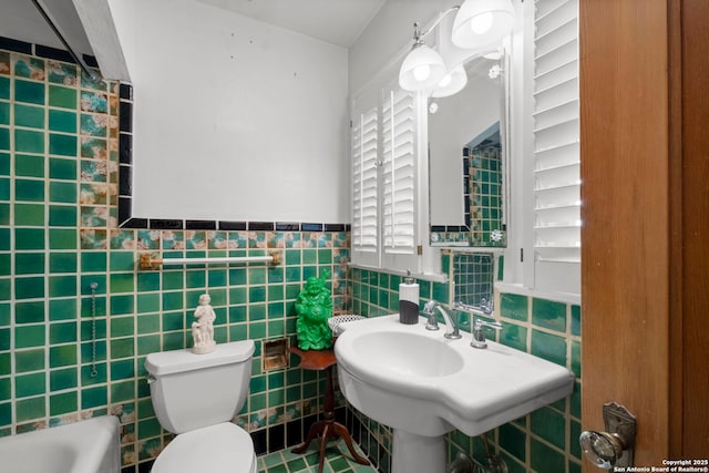 243 E Lullwood, San Antonio, TX 78212 - bathroom featuring a sink, toilet, tile walls, a tub, and wainscoting
