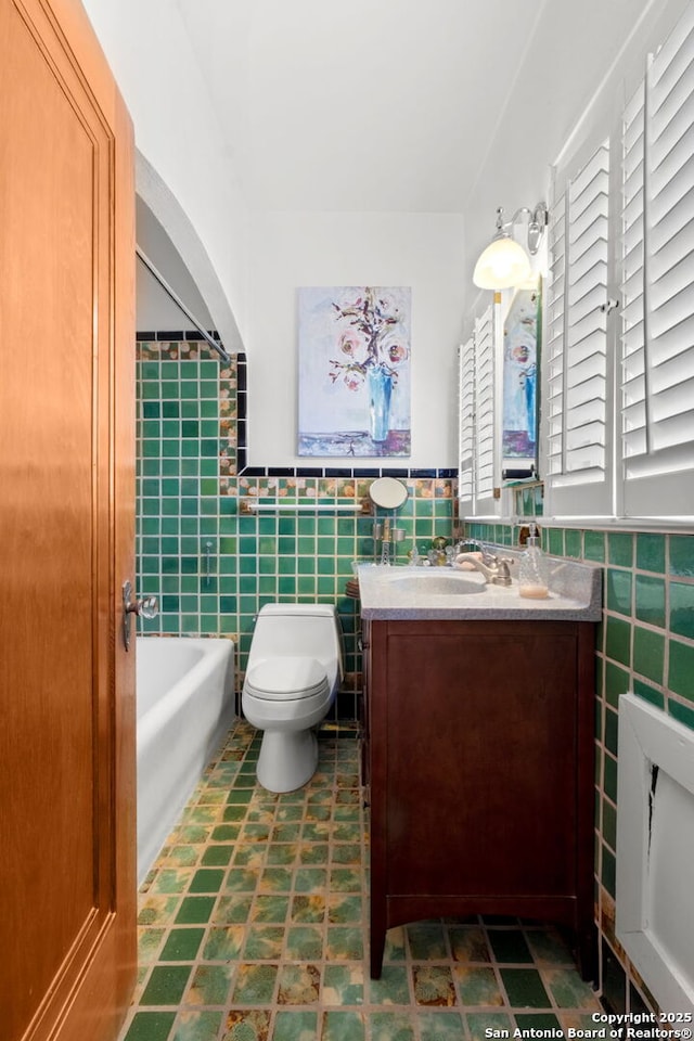 243 E Lullwood, San Antonio, TX 78212 - bathroom with vanity, tile walls, toilet, and wainscoting