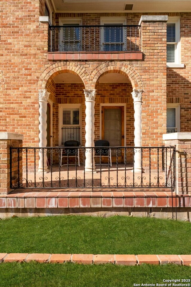 243 E Lullwood, San Antonio, TX 78212 - view of exterior entry with brick siding and a balcony