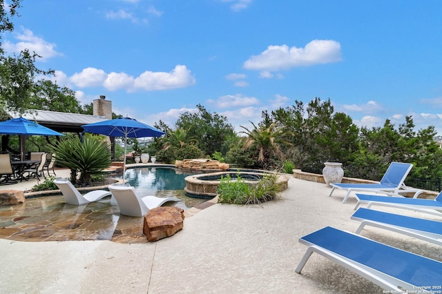 view of swimming pool with a pool with connected hot tub and a patio area