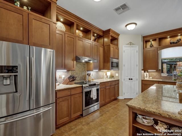 1236 Primrose Path, Canyon Lake, TX 78133 - kitchen featuring open shelves, stainless steel appliances, and visible vents