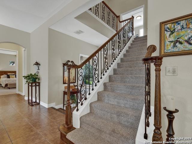 1236 Primrose Path, Canyon Lake, TX 78133 - staircase with arched walkways, visible vents, tile patterned flooring, and baseboards