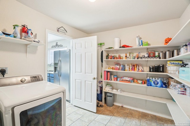 clothes washing area with light tile patterned flooring, laundry area, hookup for an electric dryer, and a sink