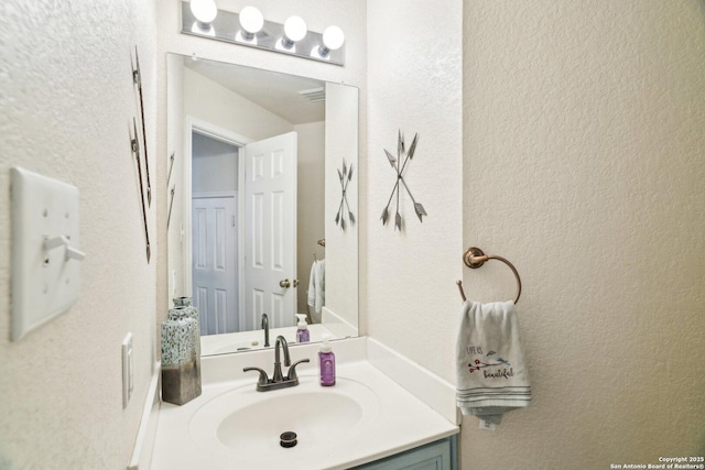 bathroom with vanity and a textured wall
