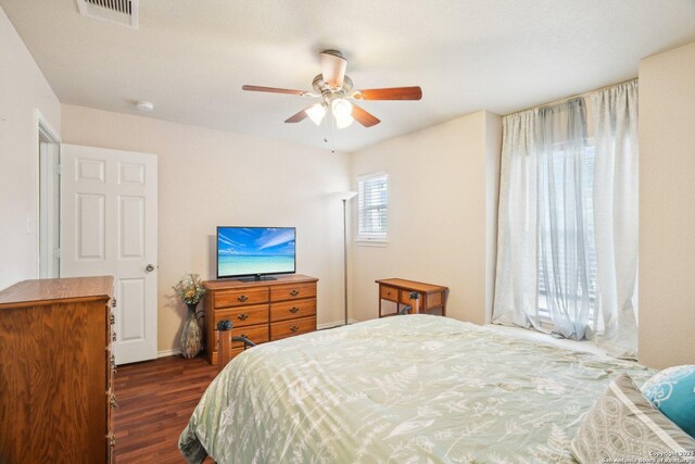 bedroom with visible vents, a ceiling fan, and dark wood finished floors