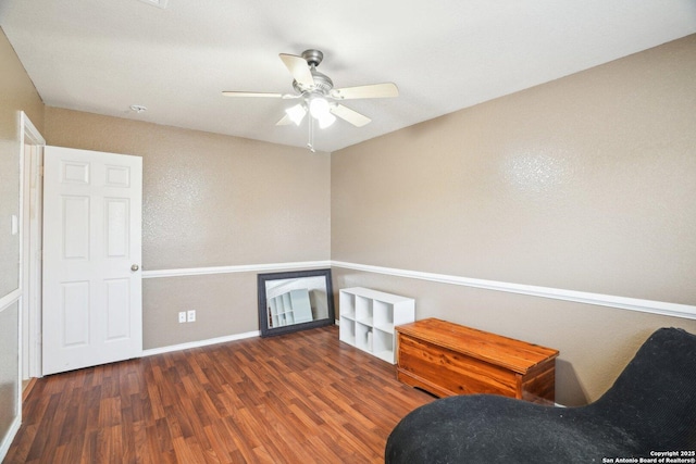 sitting room with ceiling fan, baseboards, and wood finished floors