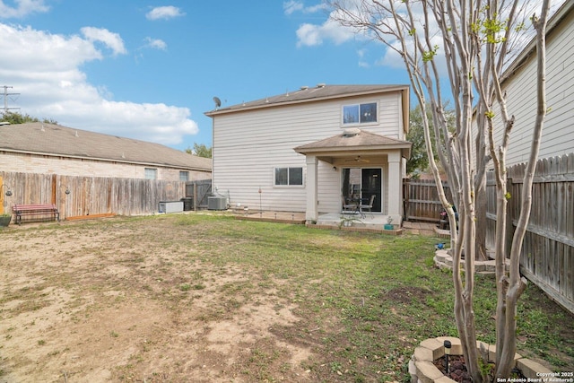rear view of property featuring a patio area, a ceiling fan, a lawn, a fenced backyard, and cooling unit