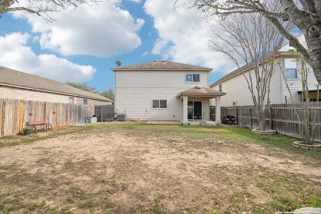 rear view of property featuring a patio area, a fenced backyard, cooling unit, and a lawn