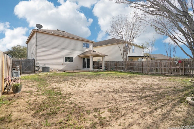 rear view of property featuring central AC unit, a fenced backyard, and a patio