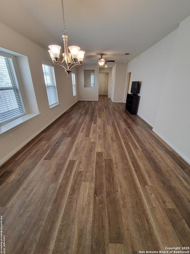 1976 Cowan Dr, New Braunfels, TX 78132 - unfurnished living room featuring ceiling fan with notable chandelier, dark wood-style flooring, and baseboards