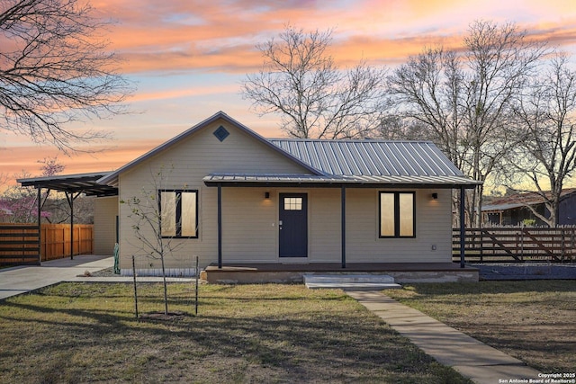 bungalow-style home featuring a yard, metal roof, and fence