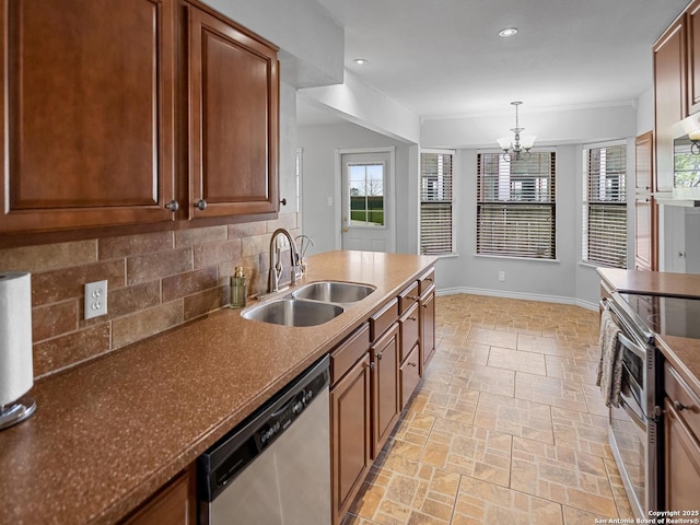 kitchen featuring baseboards, an inviting chandelier, a sink, stainless steel appliances, and tasteful backsplash