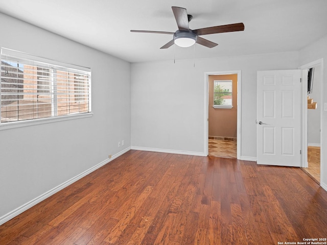 spare room featuring baseboards, ceiling fan, and wood finished floors
