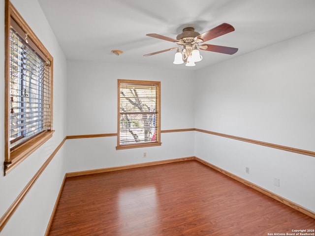 spare room with ceiling fan, baseboards, and wood finished floors