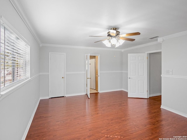 empty room featuring visible vents, crown molding, baseboards, ceiling fan, and wood finished floors
