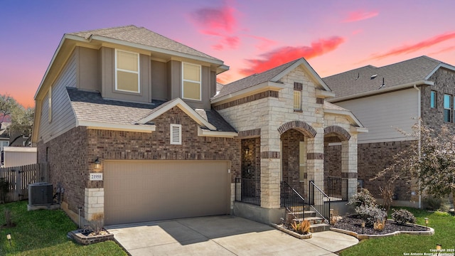 21950 Akin Byu, San Antonio, TX 78261 - view of front of home with cooling unit, roof with shingles, concrete driveway, an attached garage, and brick siding