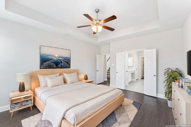 21950 Akin Byu, San Antonio, TX 78261 - bedroom featuring baseboards, dark wood-type flooring, and a tray ceiling