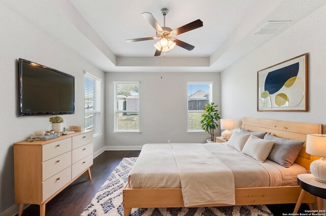 21950 Akin Byu, San Antonio, TX 78261 - bedroom featuring visible vents, baseboards, a raised ceiling, ceiling fan, and dark wood-style flooring