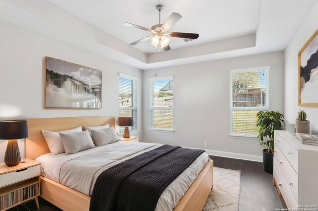 21950 Akin Byu, San Antonio, TX 78261 - bedroom with a tray ceiling, baseboards, dark wood-type flooring, and ceiling fan