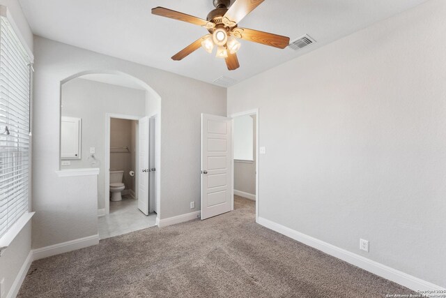 21950 Akin Byu, San Antonio, TX 78261 - unfurnished bedroom featuring arched walkways, visible vents, light colored carpet, and baseboards