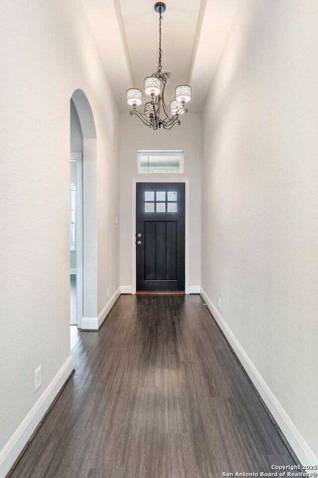 21950 Akin Byu, San Antonio, TX 78261 - entryway featuring baseboards, arched walkways, dark wood-type flooring, and a notable chandelier