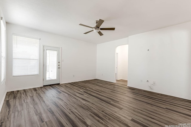 7519 Paraiso Hvn, Boerne, TX 78015 - spare room featuring arched walkways, baseboards, ceiling fan, and wood finished floors