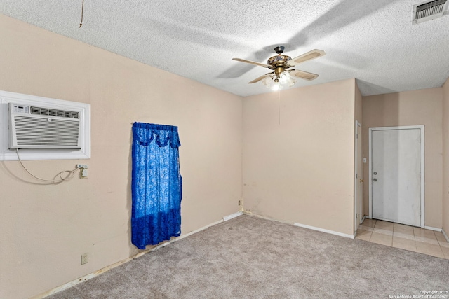 unfurnished room featuring a wall mounted air conditioner, visible vents, a textured ceiling, light colored carpet, and ceiling fan