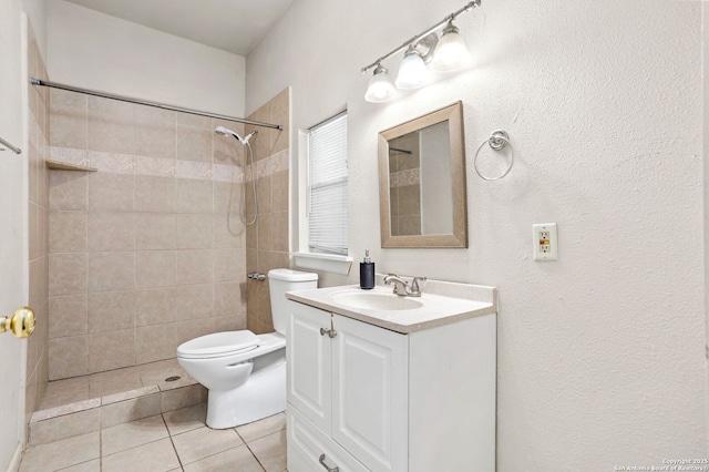 full bath featuring a tile shower, tile patterned flooring, toilet, and vanity