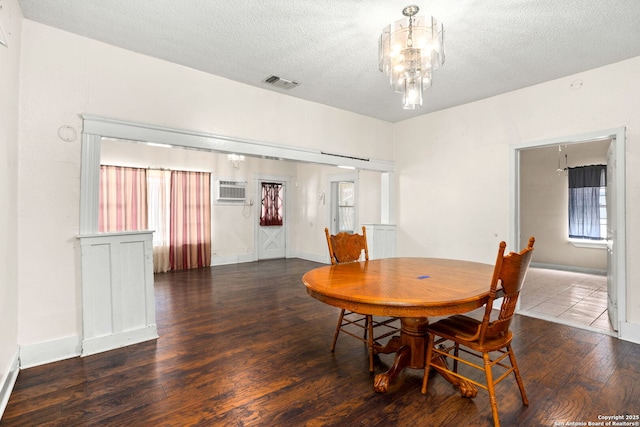 dining area with an inviting chandelier, wood finished floors, visible vents, and a textured ceiling