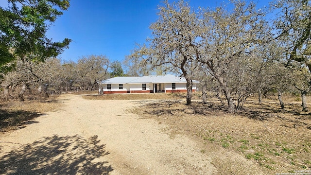 single story home featuring covered porch and dirt driveway