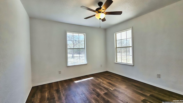 empty room with baseboards, a textured ceiling, ceiling fan, and dark wood-style flooring