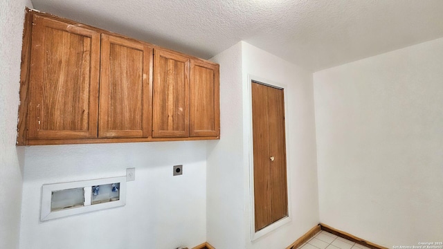 laundry area with baseboards, washer hookup, cabinet space, hookup for an electric dryer, and a textured ceiling