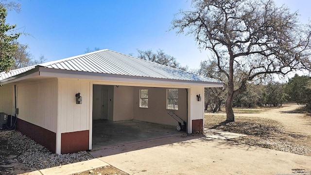 exterior space featuring metal roof and driveway