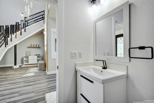 bathroom with a textured wall, wood finished floors, and vanity