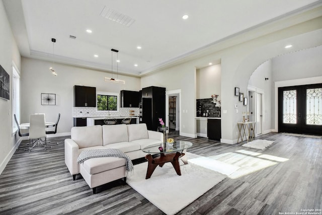 living room with arched walkways, recessed lighting, wood finished floors, and baseboards